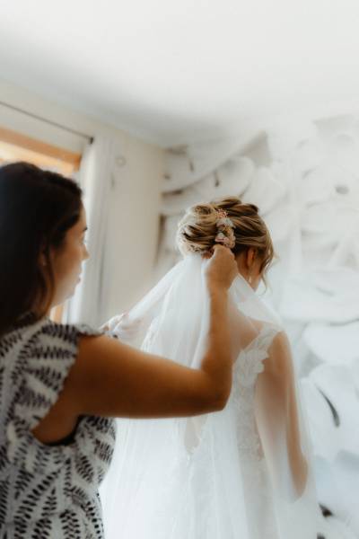 la coiffeuse place le voile en dessous de la coiffure de la mariée au domaine de la ruisseliere a lacenas proche de villefranche sur saone en rhone alpes
